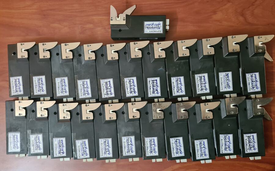 Black yarn clearer units with labels arranged in rows ready for customised setup